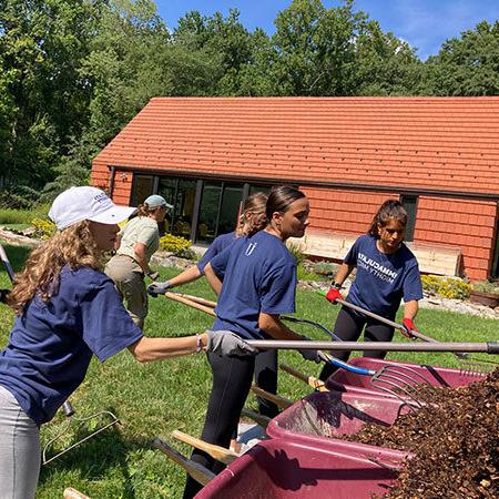 Student Service and Mission at Immaculata - 3 students working at a grounds cleanup project